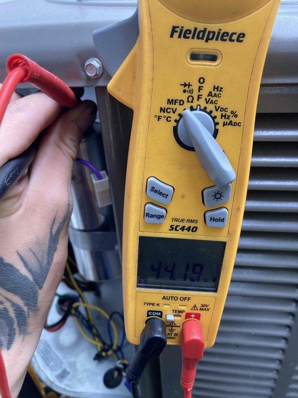 Completed prepaid AC tune-up on residential air conditioning system. Performed comprehensive maintenance including electrical diagnostics with multimeter showing 24.18V reading at control circuit, inspected refrigerant lines and copper piping connections, and examined condenser coil and internal components. All systems operating within normal parameters with no deficiencies noted.