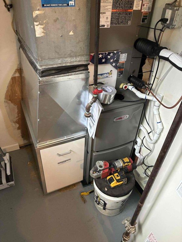 Completed full HVAC system installation including 70,000 BTU Lennox furnace, 3-ton air conditioning unit, air handler, hot water heater, and humidifier in utility closet. Performed all mechanical and electrical connections per manufacturer specifications. Installed copper refrigerant lines with brass fittings and white PVC condensate drainage system. Mounted air handler vertically above furnace cabinet with proper clearances. Connected all supply and return ductwork to new equipment. Ran refrigerant lines to outdoor condenser unit located in rear yard. Installed pressure relief valves and shut-off valves on water heater connections. Integrated humidifier into system ductwork with water supply line. Verified all electrical connections at equipment and disconnect switches. Tested system operation including heating, cooling, and humidification functions. Confirmed proper airflow, refrigerant pressures, and combustion safety on furnace. System operational and ready for service.