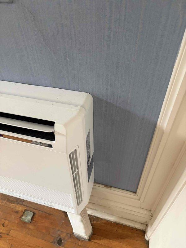 Responded to callback for mini split re-anchoring service. Upon arrival, found portable air conditioning units in use rather than wall-mounted mini split heads as indicated in service request. Documented existing equipment with photographs showing portable AC units positioned in room corners with exhaust hoses, confirming no mini split heads present at location requiring wall anchor work.