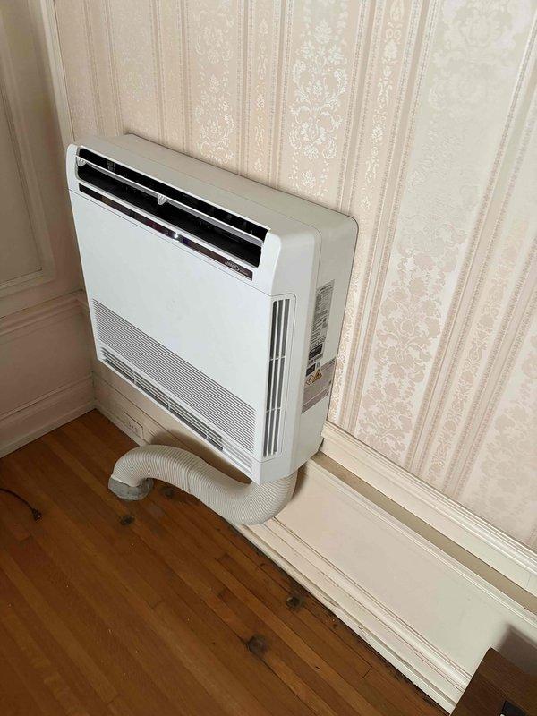 Responded to callback for mini split re-anchoring service. Upon arrival, found portable air conditioning units in use rather than wall-mounted mini split heads as indicated in service request. Documented existing equipment with photographs showing portable AC units positioned in room corners with exhaust hoses, confirming no mini split heads present at location requiring wall anchor work.
