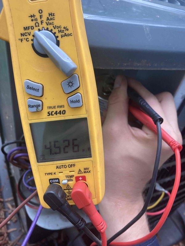 Completed prepaid AC tune-up maintenance on residential air conditioning system. Performed comprehensive system inspection including electrical diagnostics using digital multimeter to verify proper voltage and amperage readings at motor assembly. Inspected blower motor, fan wheel assembly, and mounting components for proper operation and wear. All electrical connections tested and found within manufacturer specifications. System operating efficiently with no issues identified. Captured documentation photos of electrical measurements and internal blower assembly components for service records.