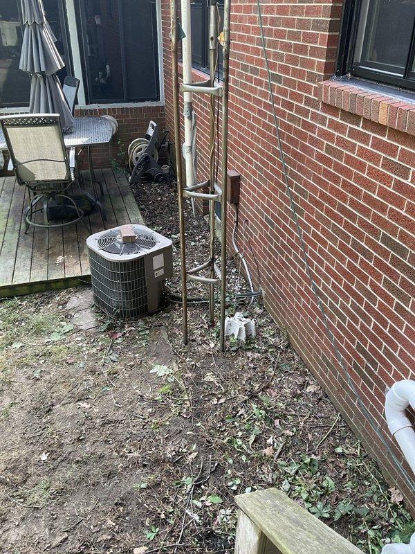 Conducted on-site evaluation of existing residential air conditioning condenser unit located in side yard against brick exterior wall. Assessed current system condition, documented equipment age and wear patterns, photographed installation including refrigerant line routing and electrical connections. Provided comprehensive replacement estimate for new AC system to homeowner.