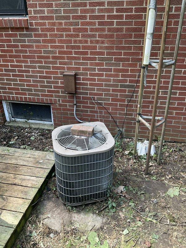 Conducted on-site evaluation of existing residential air conditioning condenser unit located in side yard against brick exterior wall. Assessed current system condition, documented equipment age and wear patterns, photographed installation including refrigerant line routing and electrical connections. Provided comprehensive replacement estimate for new AC system to homeowner.