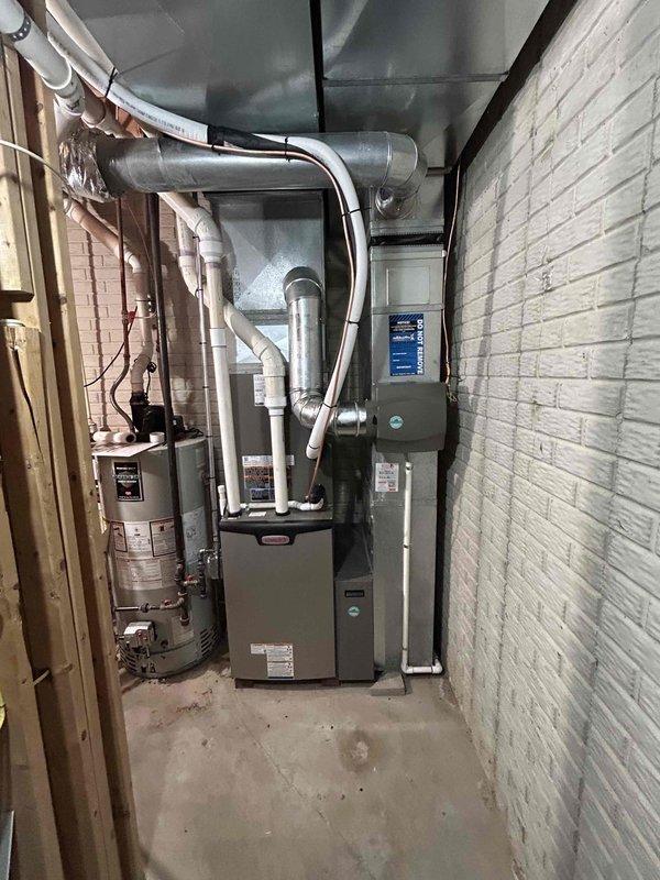Completed full HVAC system installation including a 90,000 BTU furnace and 3.5-ton air conditioning unit positioned in the right side yard. Performed all mechanical and electrical connections, installed humidifier system, and reconnected existing utilities. The new furnace was installed in the basement utility room with proper ductwork routing and ventilation, all gas lines and electrical wiring were installed to code specifications, and the outdoor condensing unit was set and connected with appropriate refrigerant lines and drainage.