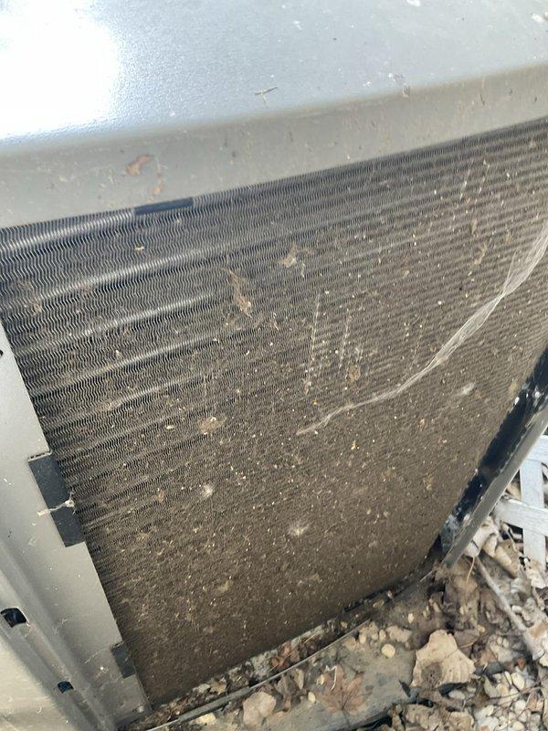 Completed preventive maintenance agreement visit on residential air conditioning system. Performed thorough inspection of outdoor condenser unit, documenting heavy dust and debris accumulation on coil fins and collection of leaves and particulate matter at base of unit. Accessed indoor air handler components, inspecting electrical connections, capacitor, and refrigerant lines, verifying all wiring and mechanical components were secure and functioning properly.