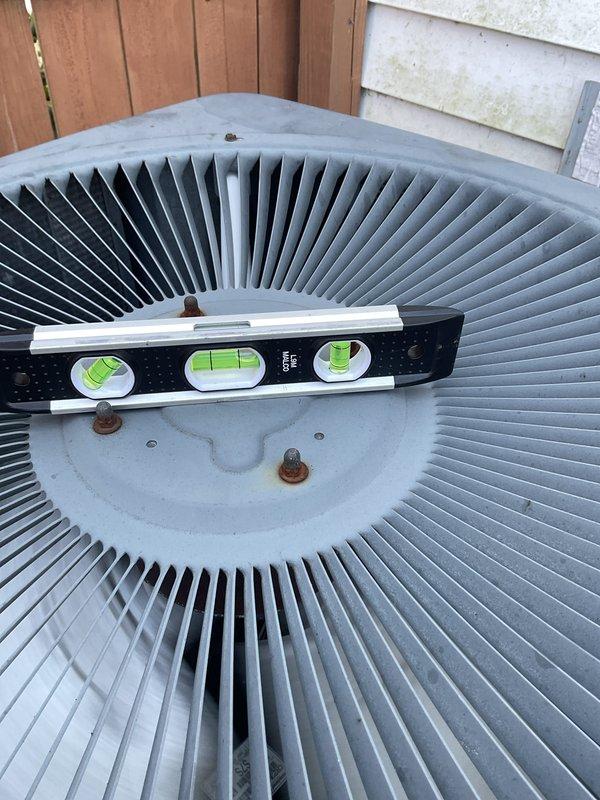 Completed preventive maintenance agreement visit on residential air conditioning system. Performed comprehensive inspection of condenser unit, including examination of evaporator coil which showed normal operational condition with typical surface discoloration from use. Verified condenser fan assembly and radial fin arrangement for proper configuration and clearance. Confirmed unit level and mounting stability using precision leveling tool to ensure optimal performance and prevent premature wear. All components operating within normal parameters with no deficiencies noted. System ready for continued seasonal operation.