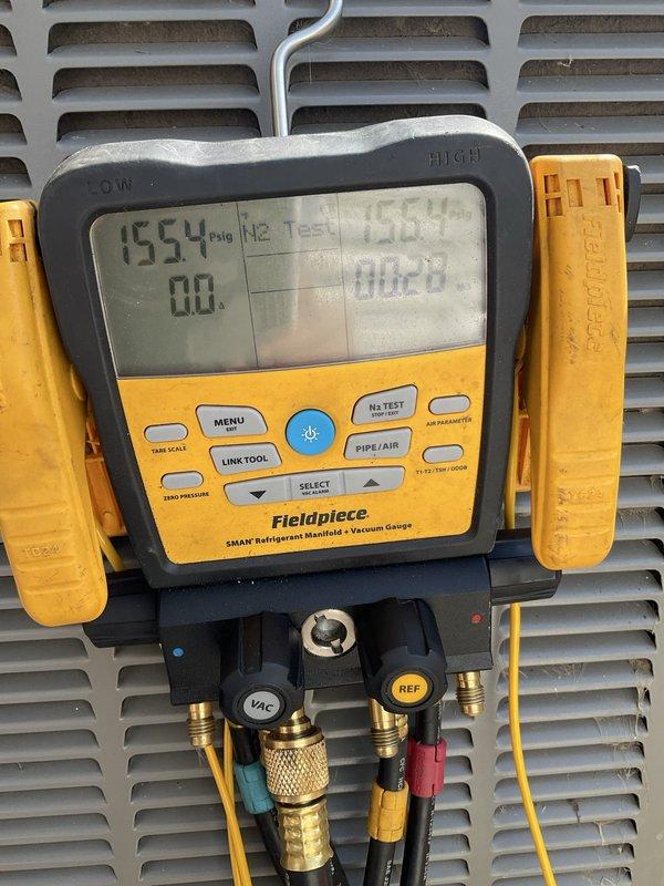 Relocated outdoor condensing unit 8-12 feet from original position. Performed nitrogen pressure test on refrigerant lines at 1554 psig to verify system integrity and check for leaks following the relocation. System held pressure successfully with no detected leaks, confirming proper line connections and brazed joints after equipment move.