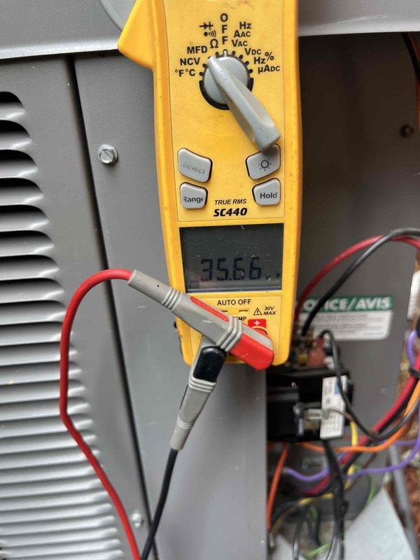 Completed Club AC12-4 preventive maintenance agreement visit on air conditioning system. Performed electrical diagnostics using digital multimeter, measuring voltage at 35.66V on system components and verifying current draw at 0.97A at the outdoor unit electrical panel. Inspected condenser unit wiring connections, contactors, and relays to ensure proper operation and electrical safety compliance.
