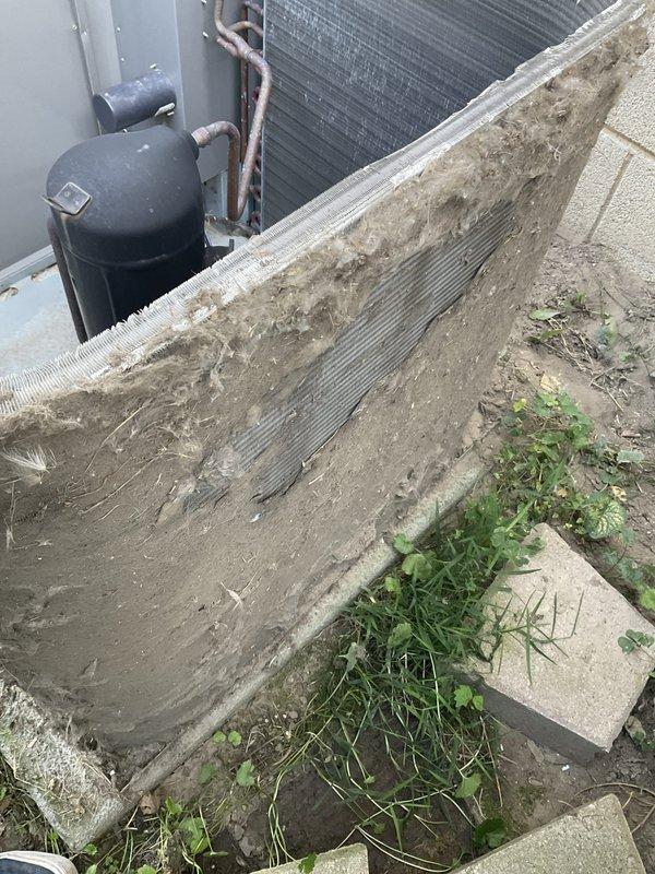 # HVAC Service Completed

Responded to no-cool call with blank thermostat display on 10+ year old system. Upon arrival, found outdoor condensing unit with severely restricted airflow due to heavily soiled condenser coil covered in thick accumulation of dirt, dust, and debris. Air filter also showed significant buildup of fibrous material and grime, indicating extended period without maintenance.

Performed thorough coil cleaning to restore proper heat transfer and system airflow. Replaced dirty air filter with new filter to manufacturer specifications. Verified proper thermostat operation and system startup. Unit now cooling effectively with restored efficiency.