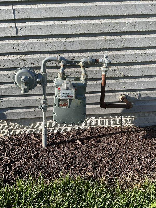 Conducted on-site assessment for new whole home generator installation at manufactured home. Evaluated existing electrical service equipment including digital smart meter, main disconnect panel, and associated conduit routing on exterior wall. Inspected natural gas meter infrastructure and supply lines to confirm adequate fuel source capacity and proper positioning for generator connection.