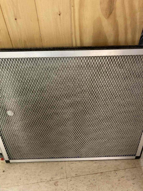 Completed Club AC8-12 preventive maintenance agreement visit on air conditioning system. Inspected and photographed air filter showing significant dust and debris accumulation on mesh screen. Performed electrical diagnostics using digital multimeter, recording voltage readings of 4.99 on system components to verify proper operation and electrical integrity of HVAC equipment.