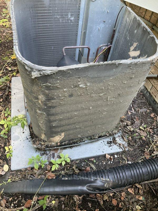 Completed preventative maintenance agreement visit on outdoor HVAC unit. Upon arrival, found exterior casing severely deteriorated with significant damage to lower front section, exposing internal condenser coils, copper refrigerant lines, and electrical components. Unit showed extensive weathering, debris accumulation, and vegetation growth around base and within equipment compartment. Documented current condition with photographs showing compromised protective housing, accumulated organic debris around compressor assembly, and exposed internal components. Unit remains operational but exterior damage poses risk to internal components from environmental exposure and debris infiltration. Recommend replacement of damaged exterior casing and clearance of vegetation and debris to prevent future damage to condenser coils and electrical connections.