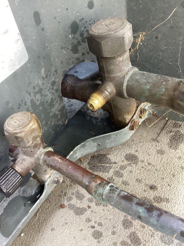 Completed Club AC10-2 preventive maintenance agreement visit for air conditioning and system inspection. Inspected exterior refrigerant line connections and service valves, noting aged brass fittings with weathering and patina consistent with outdoor installation. Verified refrigerant charge using calibrated digital scale, obtaining system weight measurement to confirm proper charge levels and system performance parameters are within manufacturer specifications.
