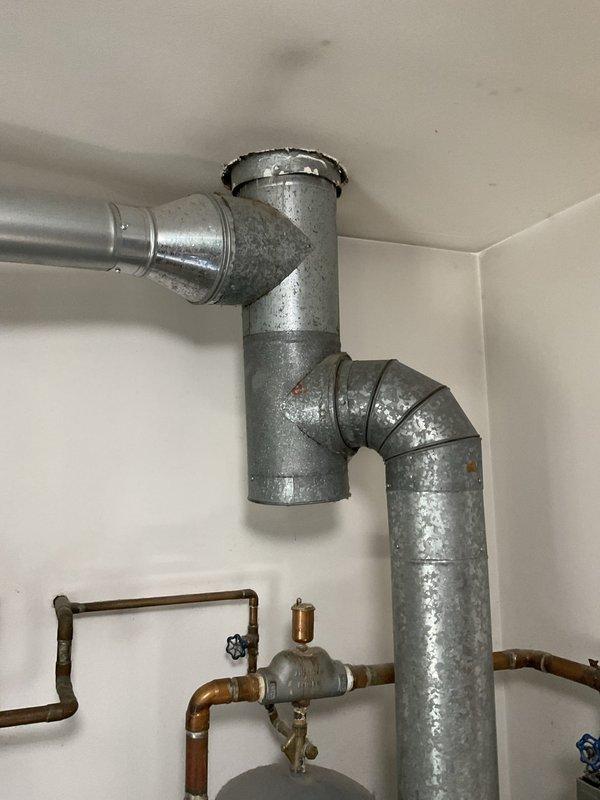 Conducted on-site evaluation for hot water boiler replacement estimate. Existing 30+ year old natural gas-fired boiler currently operational but scheduled for replacement due to age. System services hot water baseboard heating distribution. Assessed existing mechanical room infrastructure including copper supply and return piping, gas lines, and ductwork configuration. Documented wall-mounted thermostat and control system locations for replacement coordination.