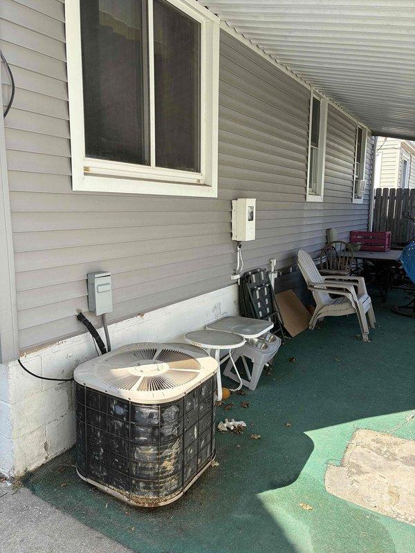 Provided comprehensive estimate for complete AC system replacement. Current outdoor condensers located on covered patio show significant age-related deterioration including rust staining, discoloration, and weathering, with units confirmed non-operational. Assessed existing infrastructure including electrical service panel, basement mechanical room with exposed utilities, and evaluated copper refrigerant line routing between outdoor equipment and basement air handler location for full system replacement specifications.