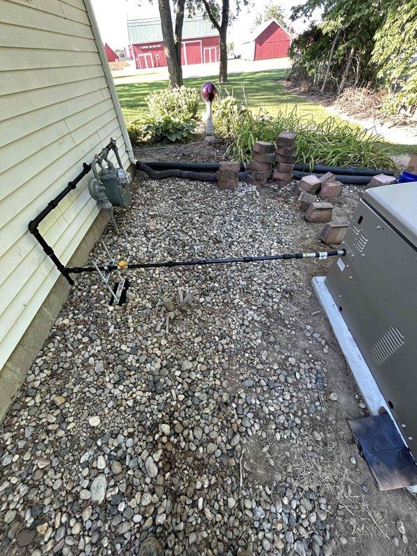Completed comprehensive generator installation including 200 AMP electrical service upgrade, natural gas piping connection to existing meter, and full mechanical and electrical integration. Performed final startup procedures with battery connection and system testing to verify proper operation. All components installed per manufacturer specifications with gas line routing along exterior wall to generator unit positioned on gravel pad adjacent to existing HVAC equipment.