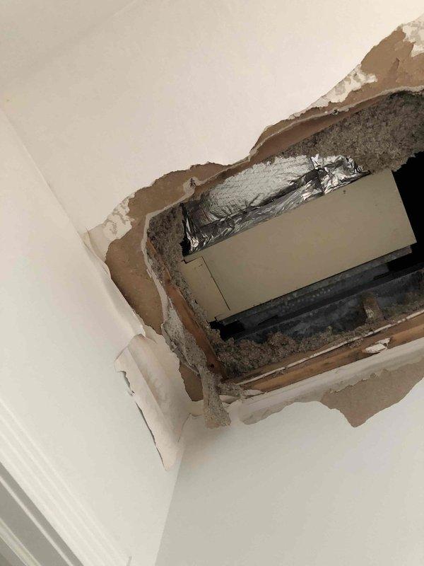 Responded to callback regarding reported ceiling damage in area of HVAC system. Upon arrival, conducted thorough inspection and documented extensive ceiling and wall deterioration with visible water staining, exposed framing, insulation, and ductwork. Damage pattern indicates previous or ongoing moisture intrusion affecting structural drywall and ceiling materials. Photographed all affected areas including compromised interior surfaces, exposed reflective vapor barrier, and dark rectangular vent component within damaged section. Also documented equipment condition showing wear patterns, deteriorated finish on metal surfaces, and accumulated debris at gasket seals. Findings suggest water damage may be related to HVAC condensate issues or ductwork concerns requiring further evaluation and remediation by appropriate trades.