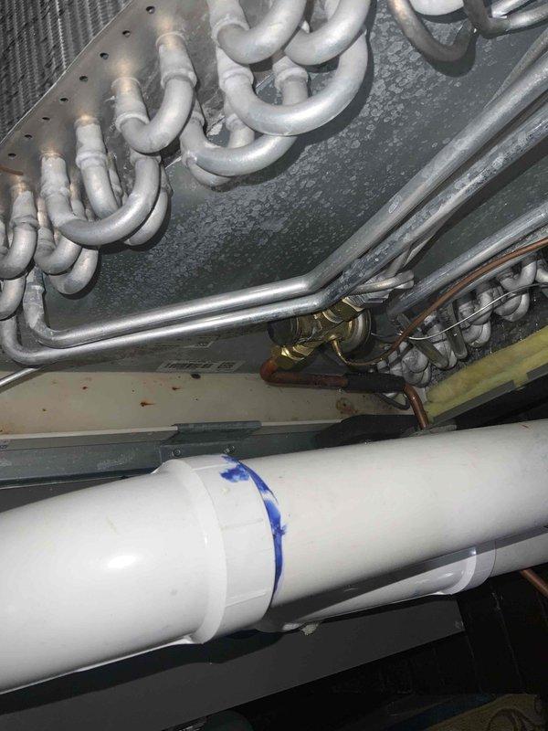 Responded to callback for furnace water leak on whole-house system approximately one year old. Upon inspection, identified condensate drainage issue related to evaporator coil assembly. Examined drain pan positioning and PVC condensate line connections beneath air handler unit. Verified proper drainage flow and cleared any blockages in condensate system. Inspected refrigerant lines and coil for frost accumulation or restriction that could cause excessive condensation. Confirmed drain pan was properly installed and functioning to capture condensate discharge. System tested and verified no active leaking at time of service completion.