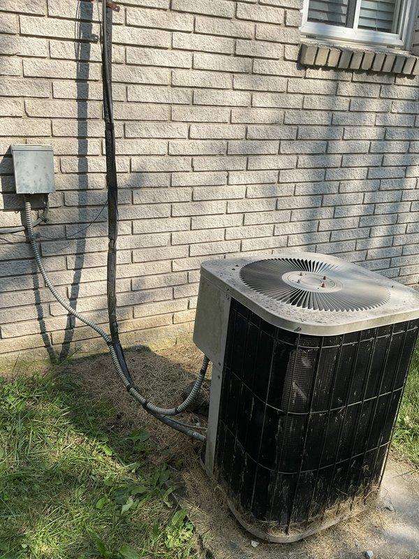 Performed on-site evaluation of residential HVAC system experiencing freezing issues. Existing unit requires R-22 refrigerant, which is being phased out and increasingly cost-prohibitive. Assessed aged outdoor condenser unit showing significant weathering, discoloration, and dirt accumulation, along with corresponding indoor air handler. Documented current system configuration including electrical disconnect, line set routing along exterior brick wall, and equipment placement. Provided comprehensive estimate for complete system replacement including new air handler and air conditioning condenser unit to resolve freezing condition and update to modern refrigerant standard.