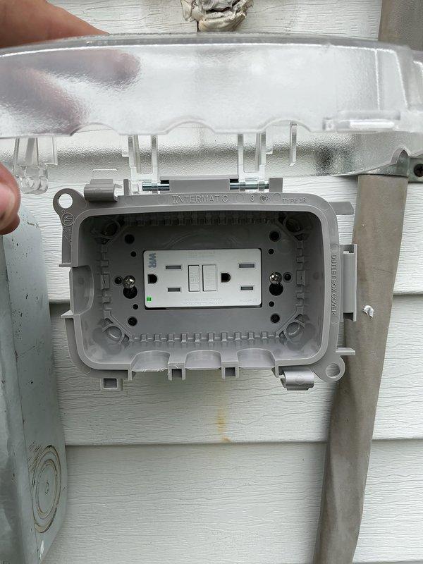 Installed outdoor GFCI receptacle in weatherproof Intermatic enclosure on exterior siding. Wired dual outlet with integrated toggle switches and indicator light, then connected circuit to dedicated breaker in main electrical panel labeled "Outdoor GFCI." Verified proper ground fault protection and tested functionality of all outlets and switches to ensure code-compliant operation.