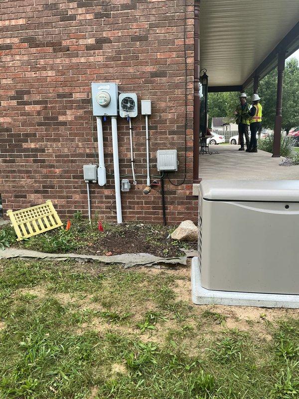 Completed electrical installation of Kohler standby generator unit on concrete pad in rear yard area. Installed exterior electrical components including meter housing, disconnect box, and conduit system with proper vertical runs connecting all electrical panels and equipment. All electrical connections, grounding, and code-compliant wiring completed for generator system integration with existing electrical service.