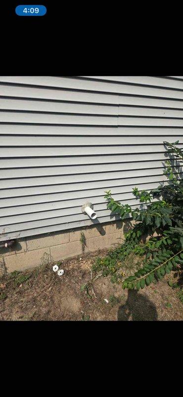 Completed warranty service for HVAC installation with customer-requested modification to route venting down into crawl space. Installed PVC venting through exterior wall and foundation area, with proper termination and support. Documentation and photographic records captured showing exterior vent penetration through siding and crawl space insulation work area.