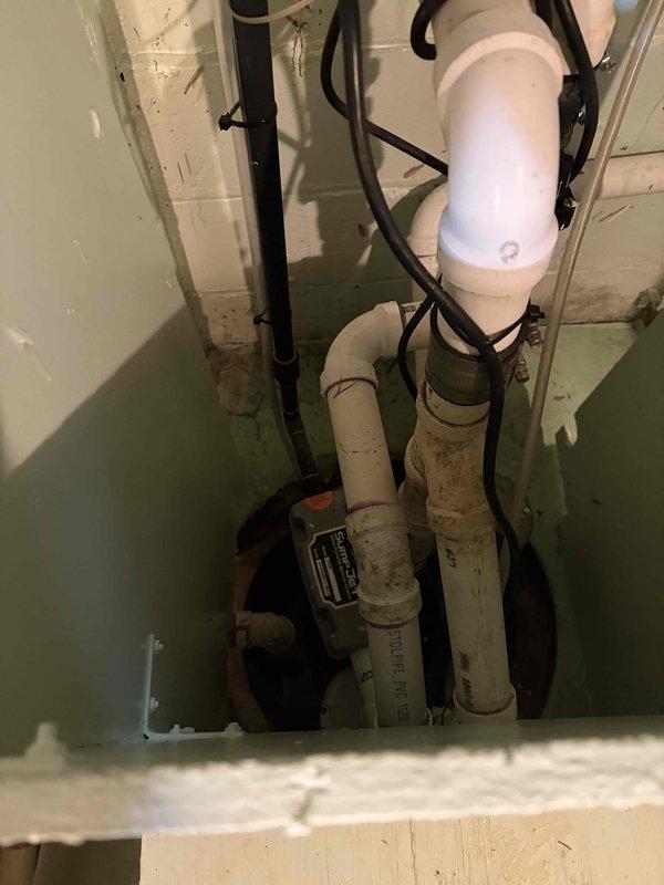 Completed full HVAC system installation including a 70,000 BTU furnace, 2-ton air conditioning system, boiler, and humidifier. Installed gray cabinet-style air handler unit in basement utility area with proper mounting and positioning. Ran and secured white PVC drainage lines from unit along floor and to ceiling using appropriate clips and connectors. Completed all electrical connections including flexible metallic conduit, junction box installation, and control panel wiring. Configured proper drainage system integration with existing sump pump pit. Verified all mechanical systems operational and reconnected electrical components per specifications.