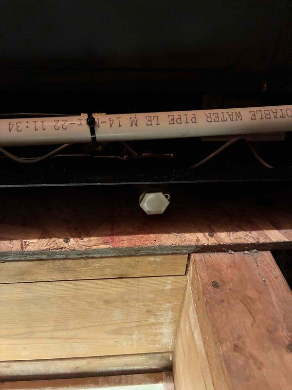 Completed warranty service by removing and replacing the failed condensate drain pan on the attic-mounted HVAC air handler. The new black metal drain pan was properly installed with PVC drainage piping reconnected and the condensate safety switch remounted in the pan to ensure proper overflow protection and system shutdown capability if needed.