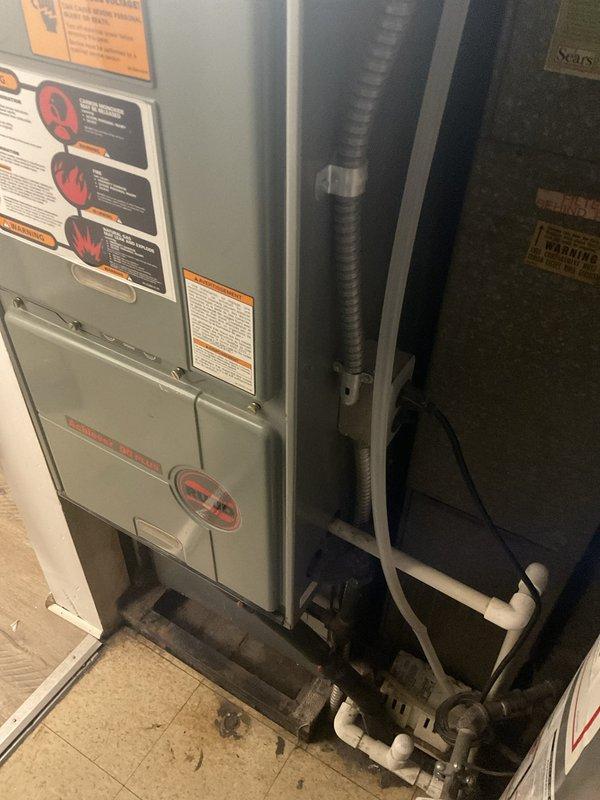 Conducted comprehensive system evaluation of 20+ year old R-22 residential HVAC system exhibiting heavy damages in basement installation. Assessed furnace unit, ductwork connections, and condensate drainage system to determine replacement requirements. Documented equipment condition through photographic evidence showing deteriorated components, floor staining indicating potential drainage issues, and aging infrastructure requiring full system replacement estimate due to obsolete refrigerant type and extensive wear beyond economical repair.
