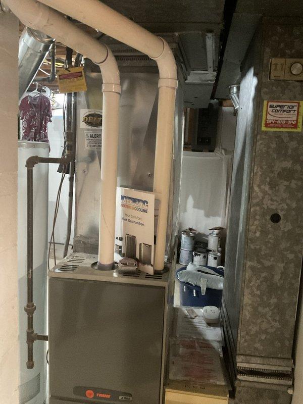 Conducted comprehensive HVAC system evaluation for failed heat exchanger in existing furnace and 14-year-old air conditioning system. Inspected basement-installed furnace unit with vertical air handler configuration, documented existing equipment condition including ductwork connections, copper refrigerant lines, and electrical components mounted on auxiliary board. Photographed current system setup showing insulated supply ducts, PVC condensate drainage, and mechanical room infrastructure. Provided detailed replacement options for both heating and cooling equipment, presenting available promotional opportunities for complete system upgrade versus single component replacement to address the compromised heat exchanger while considering the age and remaining service life of the existing AC unit.
