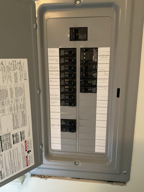 Conducted comprehensive site assessment for furnace replacement estimate. Documented existing electrical panel configuration showing dual-column breaker arrangement with main disconnect, verified circuit labeling and panel capacity for new equipment installation. Evaluated exterior utility connections including aged copper gas lines with visible corrosion, existing HVAC equipment placement on concrete pad with vegetation growth, and electrical service routing through exterior junction boxes and conduit. Assessed installation requirements and utility interface points to provide accurate replacement system specifications.