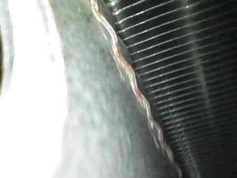 Responded to no cooling call on 10+ year old AC system. Found outdoor condensing unit not operating. Inspected condenser coil and internal components, which showed signs of age but maintained structural integrity. Photographed heat exchanger fins and copper refrigerant lines for documentation. Unit requires further diagnostic testing to determine root cause of failure, likely related to electrical components or compressor given age of system.