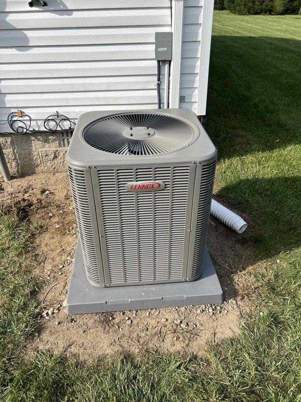 Completed full HVAC system installation including new Lennox condensing unit positioned on freshly poured concrete pad with proper leveling and clearances maintained per manufacturer specifications. All electrical connections, refrigerant lines, and drainage systems installed to code with system tested and verified operational upon completion.