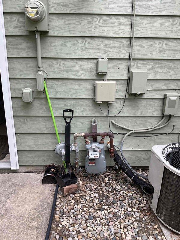 Conducted comprehensive site assessment for HVAC system replacement estimate on 23-year-old residential heating and cooling equipment. Evaluated existing exterior utility infrastructure including electrical service, gas meter assembly, and current condensing unit configuration to determine replacement requirements and compatibility with existing connections. Documented electrical disconnect box, conduit routing, gas line manifold system, and available clearances for new equipment installation to provide accurate replacement specifications and identify any necessary modifications to existing utility connections.