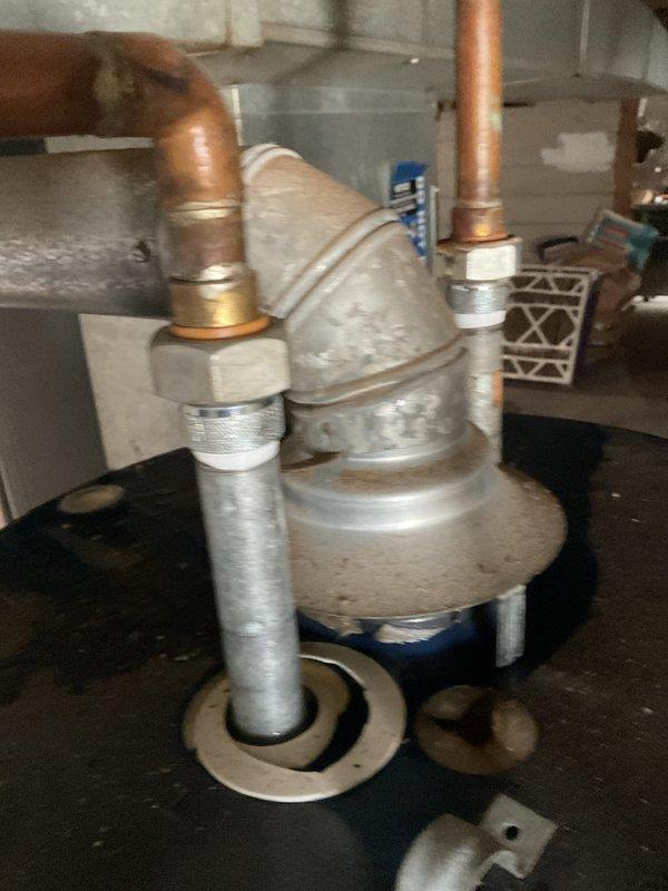 Responded to no hot water complaint and inspected tanked water heater installation in basement utility area. Upon arrival, found water heater with visible moisture staining at base and confirmed lack of hot water production. Evaluated copper supply line connections, shutoff valves, and galvanized piping assembly at top of unit. Assessed water heater condition, checked pilot light status, and verified proper gas supply and venting configuration. Performed necessary repairs to restore hot water service and tested system operation to ensure proper function before departure.