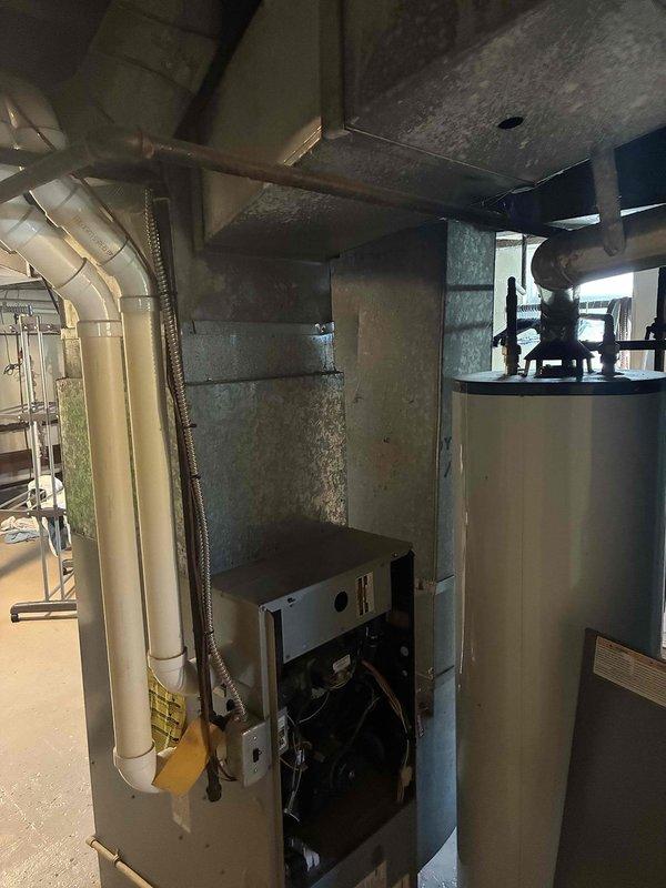 Conducted on-site evaluation of existing HVAC system and water heating equipment in residential mechanical room. Assessed current boiler unit, cylindrical water heater tank, and associated ductwork configuration. Documented equipment conditions through photographic inspection, noting existing PVC/metal ductwork routing, mechanical connections, and piping infrastructure. Provided comprehensive replacement estimate for single HVAC component based on observed system layout and mechanical specifications.