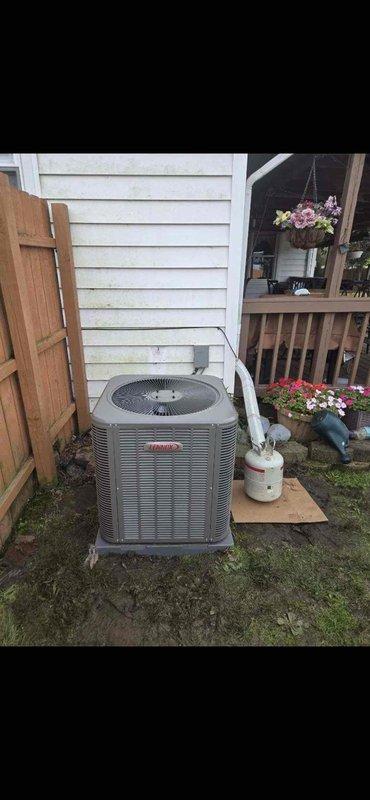Completed installation of a 2.5-ton Amana air conditioning system with outdoor condenser unit positioned on exterior pad and Goodman air handler mounted in interior utility closet. Established refrigerant line connections, electrical service, and condensate drainage system with PVC piping to ensure proper system operation and code compliance.