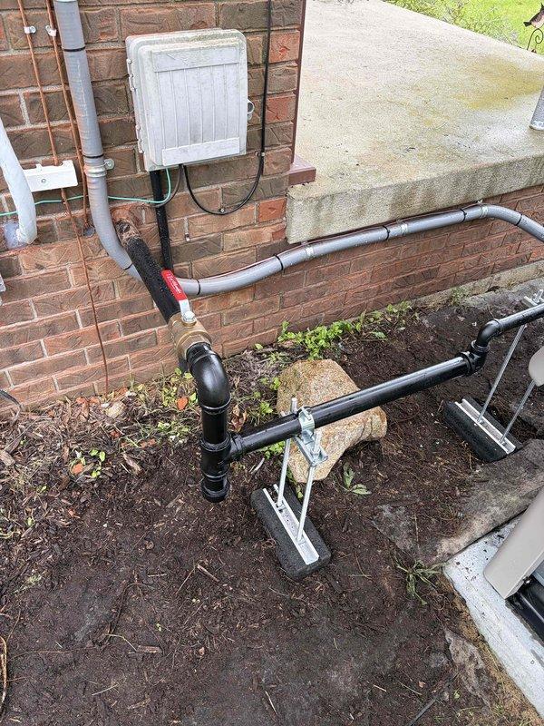 Completed installation of gas line piping for standby generator system. Routed black iron pipe from existing gas meter through foundation area with proper support brackets and fittings, installed red-handled ball valve for equipment isolation, and secured all connections per code requirements. All piping properly supported on concrete blocks with appropriate joint configuration and tested for leaks upon completion.
