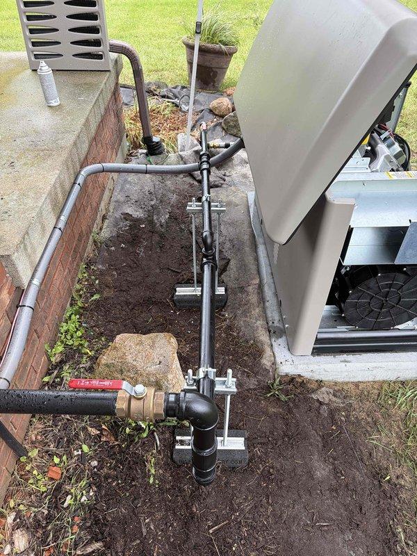 Completed installation of gas line piping for standby generator system. Routed black iron pipe from existing gas meter through foundation area with proper support brackets and fittings, installed red-handled ball valve for equipment isolation, and secured all connections per code requirements. All piping properly supported on concrete blocks with appropriate joint configuration and tested for leaks upon completion.