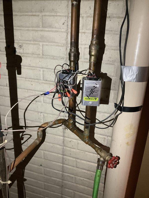 Conducted estimate for replacement of 30-year-old natural gas-fired hot water boiler system serving baseboard heating distribution. Evaluated existing installation including copper piping manifold, electrical controls, zone valves, and PVC venting configuration. Documented current system layout with aged copper supply and return lines, electrical relay components, and mechanical room conditions to provide accurate replacement specifications for new high-efficiency boiler installation.