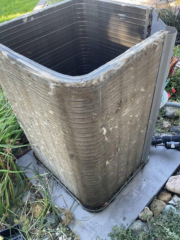Completed preventative maintenance inspection on residential outdoor air conditioning unit as part of Club AC8-12 agreement. Performed comprehensive system evaluation including visual inspection of condenser unit exterior, electrical components, capacitor, contactor, and wiring connections. All electrical connections found secure with proper color-coded wiring intact. Capacitor and contactor operating within normal parameters. Unit exterior showing typical environmental weathering with dirt and mineral deposit accumulation on casing. Condenser coils and fins accessible through top opening appear functional with age-appropriate darkening. System mounted securely on concrete pad with no structural concerns noted. Equipment photographed for service records documenting current condition of exterior cabinet and internal electrical compartment components.