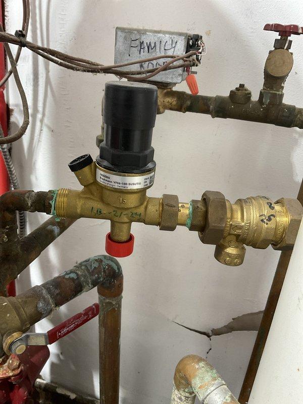 Completed routine HVAC maintenance inspection under Club Heat8-12 agreement, performing visual assessment of heating system components including pressure regulation assembly, piping connections, and safety devices. Documented existing plumbing infrastructure showing age-appropriate wear patterns, oxidation on copper and brass components, and verified proper operation of manual shut-off valves, pressure regulator, air vent with bleeder valve, and associated pipe connections throughout the water supply and heating distribution system.