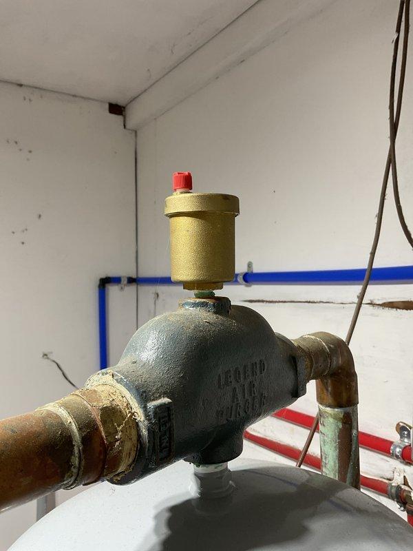 Completed routine HVAC maintenance inspection under Club Heat8-12 agreement, performing visual assessment of heating system components including pressure regulation assembly, piping connections, and safety devices. Documented existing plumbing infrastructure showing age-appropriate wear patterns, oxidation on copper and brass components, and verified proper operation of manual shut-off valves, pressure regulator, air vent with bleeder valve, and associated pipe connections throughout the water supply and heating distribution system.