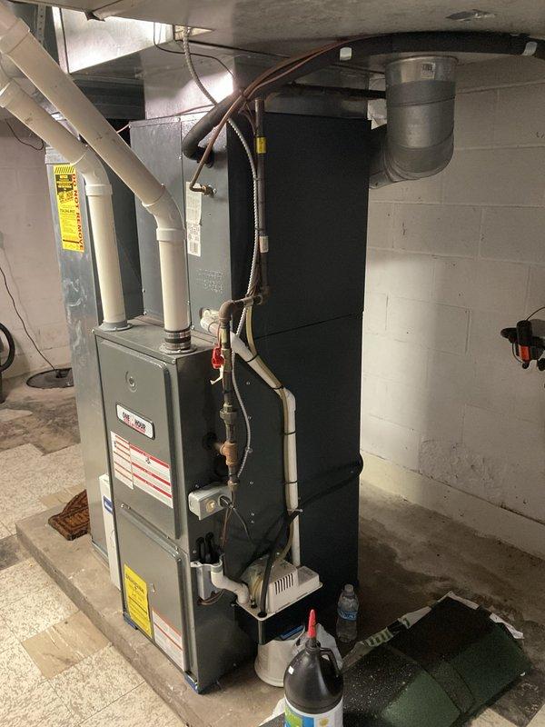 Responded to service call for failed heat exchanger evaluation on residential furnace system. Performed comprehensive inspection of existing HVAC equipment, including gray metal furnace unit with white PVC venting and associated ductwork in basement utility area. Documented current system configuration with detailed photographs showing furnace condition, venting arrangement, refrigerant line routing, and surrounding mechanical components. Assessed heat exchanger failure and provided estimate for replacement options to restore safe heating operation.