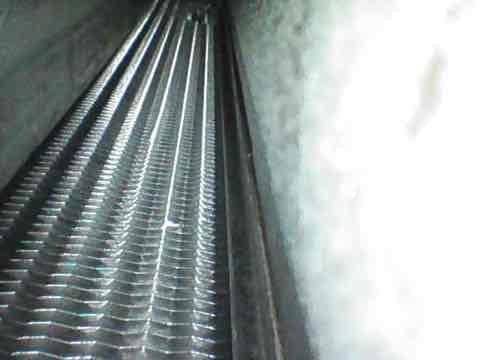 Responded to club heat/no heat service call and performed agreement visit inspection on air handler and system components. Upon inspection, evaporator coils were found to be in good operating condition with minimal dust accumulation on fin surfaces. Documented coil condition with photographs showing clean aluminum fins with proper spacing and no signs of damage, corrosion, or significant debris buildup that would restrict airflow or reduce system efficiency.