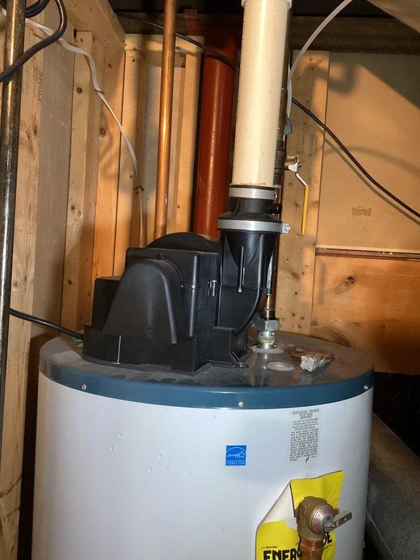 Provided estimate for power vent water heater replacement in basement utility area. Assessed existing installation including power vent system with PVC exhaust piping, evaluated clearances and venting configuration, and documented current equipment specifications for replacement proposal.