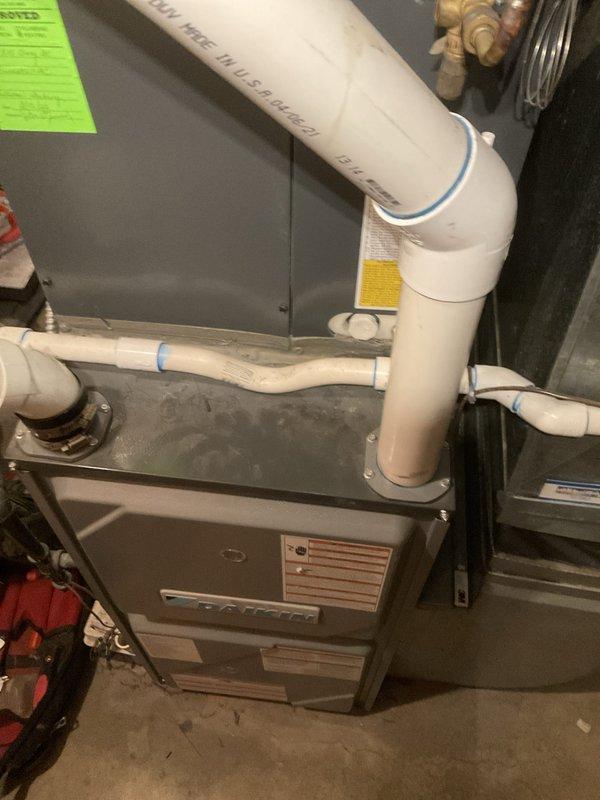 Performed comprehensive tune-up on residential furnace and air handler system. Completed full inspection of all mechanical components, verified proper operation of blower motor and heat exchanger, checked all electrical connections, tested safety controls, and inspected venting system including PVC exhaust piping. System found to be operating within normal parameters with no issues identified; green approval tag affixed to unit confirming satisfactory completion of maintenance service.