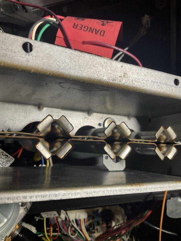 Completed routine HVAC maintenance agreement visit for club heat system 8-12. Upon inspection, accessed furnace unit and documented condition of critical components including heat exchanger assembly and electrical heating elements. Found three ceramic resistor elements showing normal heat discoloration and thermal wear patterns consistent with operational use. Verified burner assembly, gas line connections with safety caps, and electrical wiring connections. Photographed equipment interior including danger tags and component conditions for maintenance records. All systems inspected and documented per agreement visit requirements.