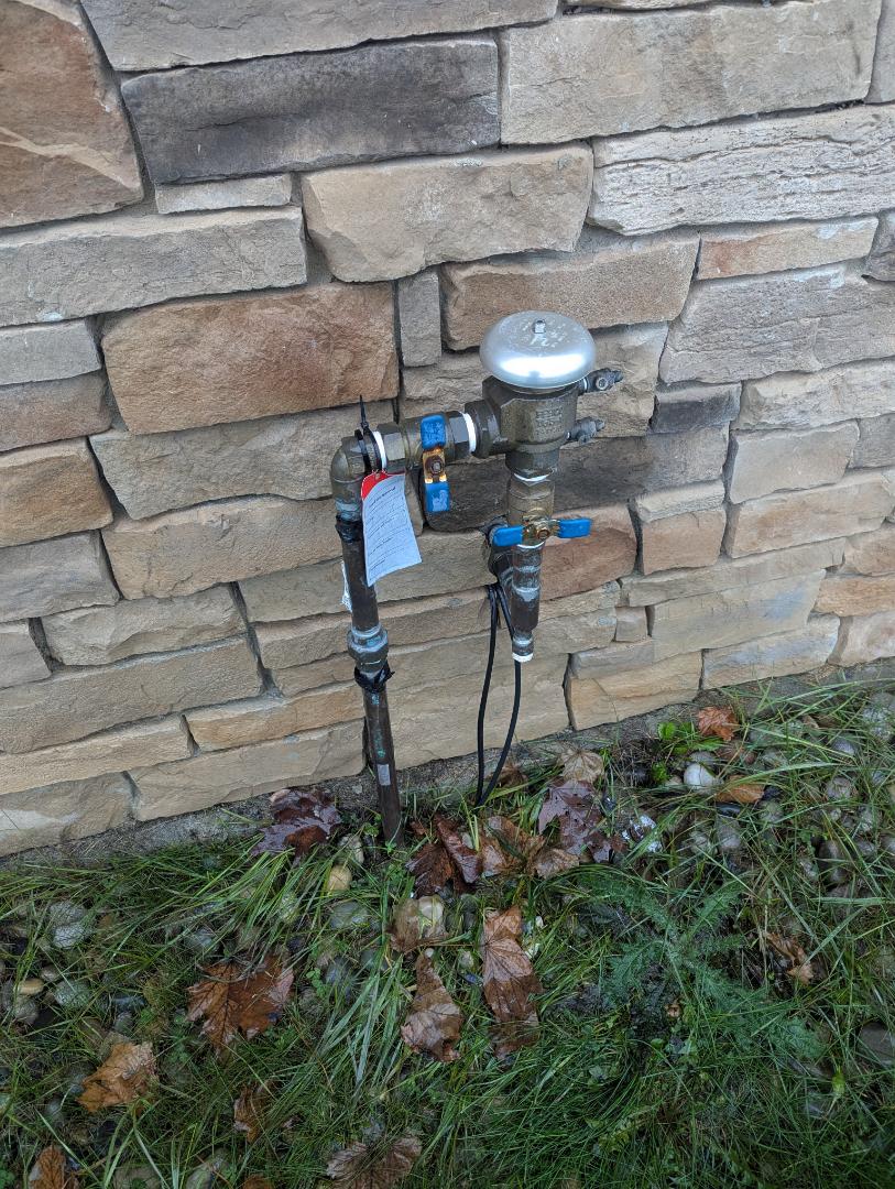 turn water off to irrigation system inside. building and drain down water on leaking pressure vacuum breaker outside.