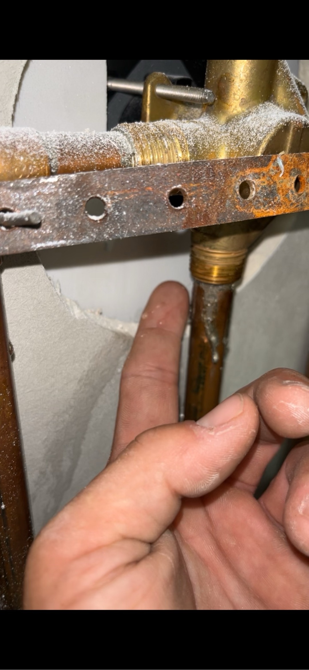 Customer had water damage to ceiling above dinning room table. Opened ceiling to inspect for leak and found that leak was coming from behind shower valve. Proceeded to open drywall in laundryroom to expose valve for secondary bathroom. Ran water and found that the copper line tying into bottom of shower valve was not properly soldered and was leaking. Removed section and re soldered. Also re tightened loose shower head arm. Ran water in bathroom for several minutes and didn’t see any further leaks. 